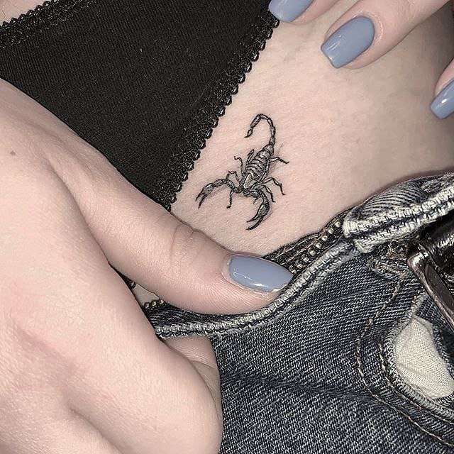 Tattoo of a scorpion on the hip for women