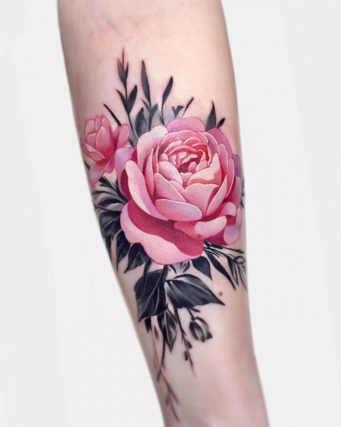 Colored peony tattoo on the forearm for women