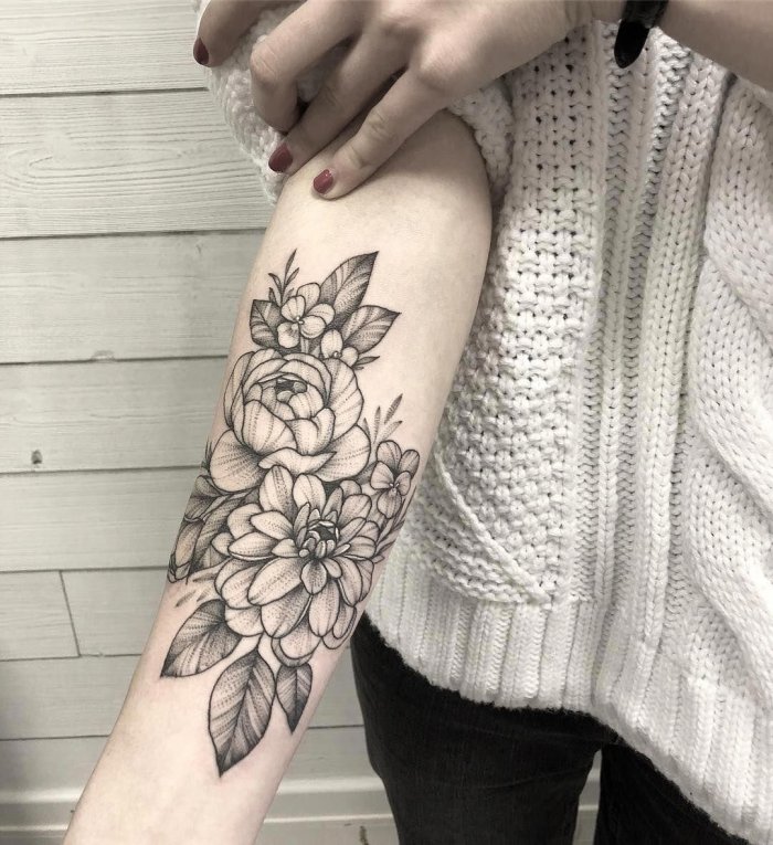 Large peony tattoo on the forearm for women