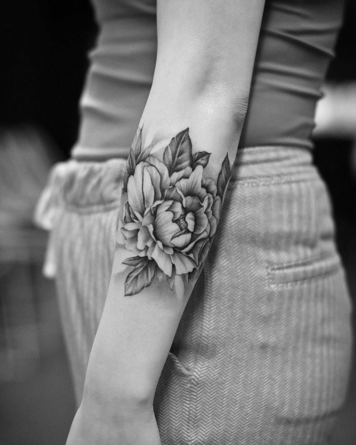 Peony tattoo on the forearm for women