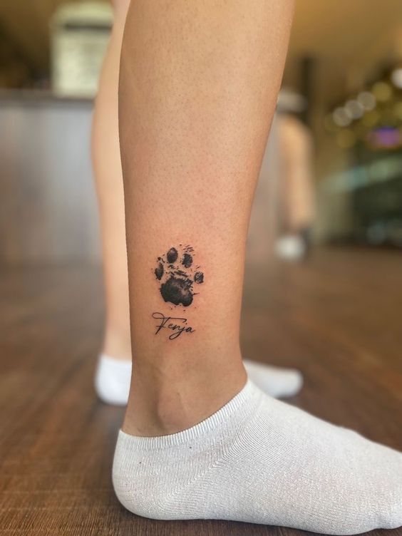 Tattoo of a dog's paw on the shin for men