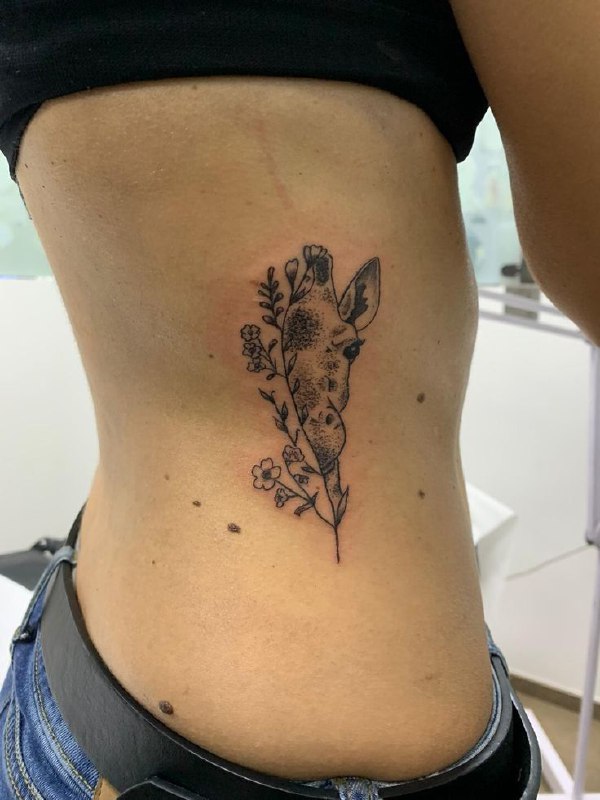 Tattoo of a giraffe on the side for women