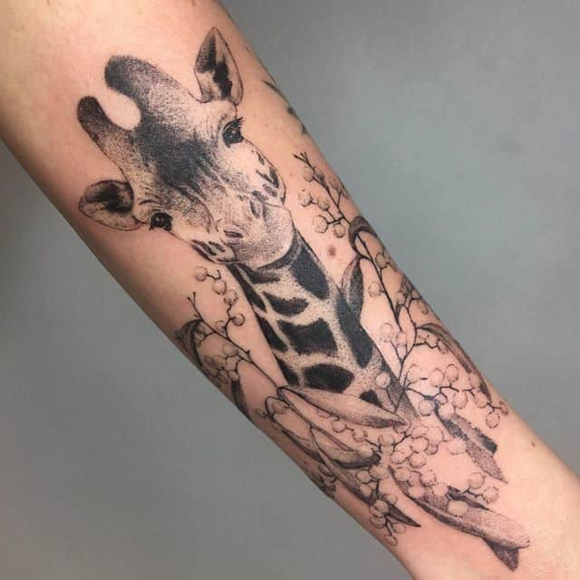 Tattoo of a giraffe on the forearm for women