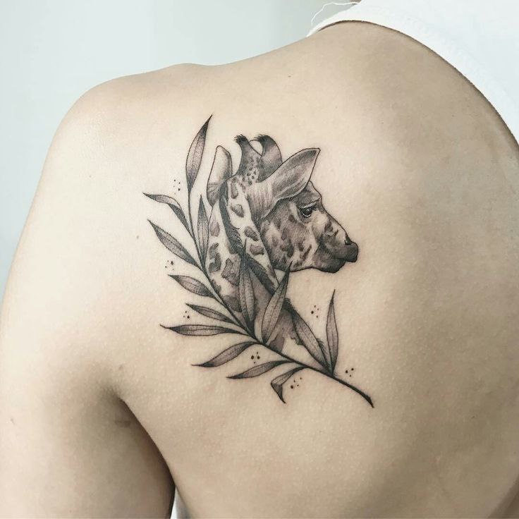 Tattoo of a giraffe on the shoulder blade for women