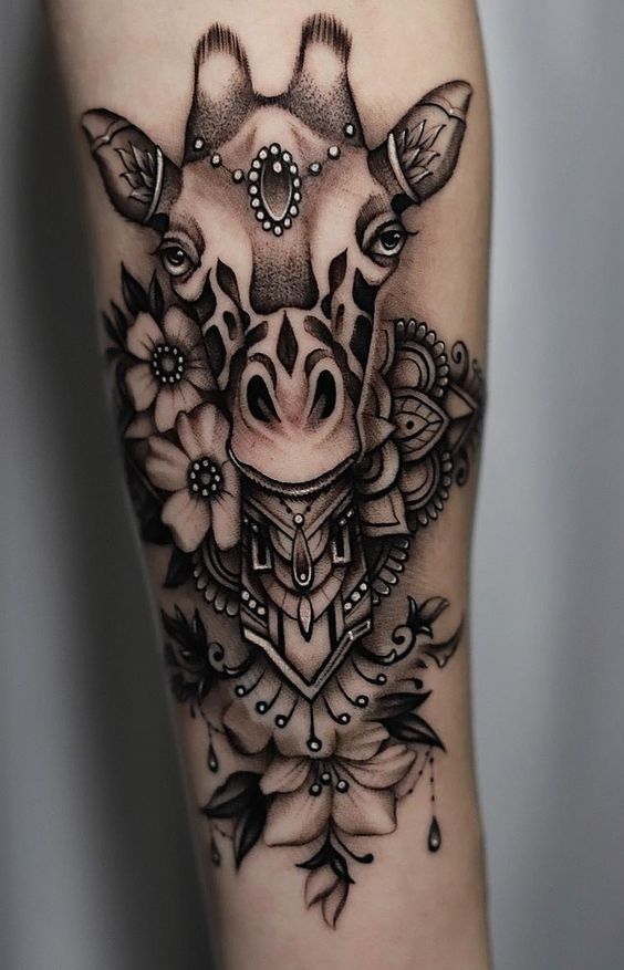 Tattoo of a giraffe and flowers on the forearm for women