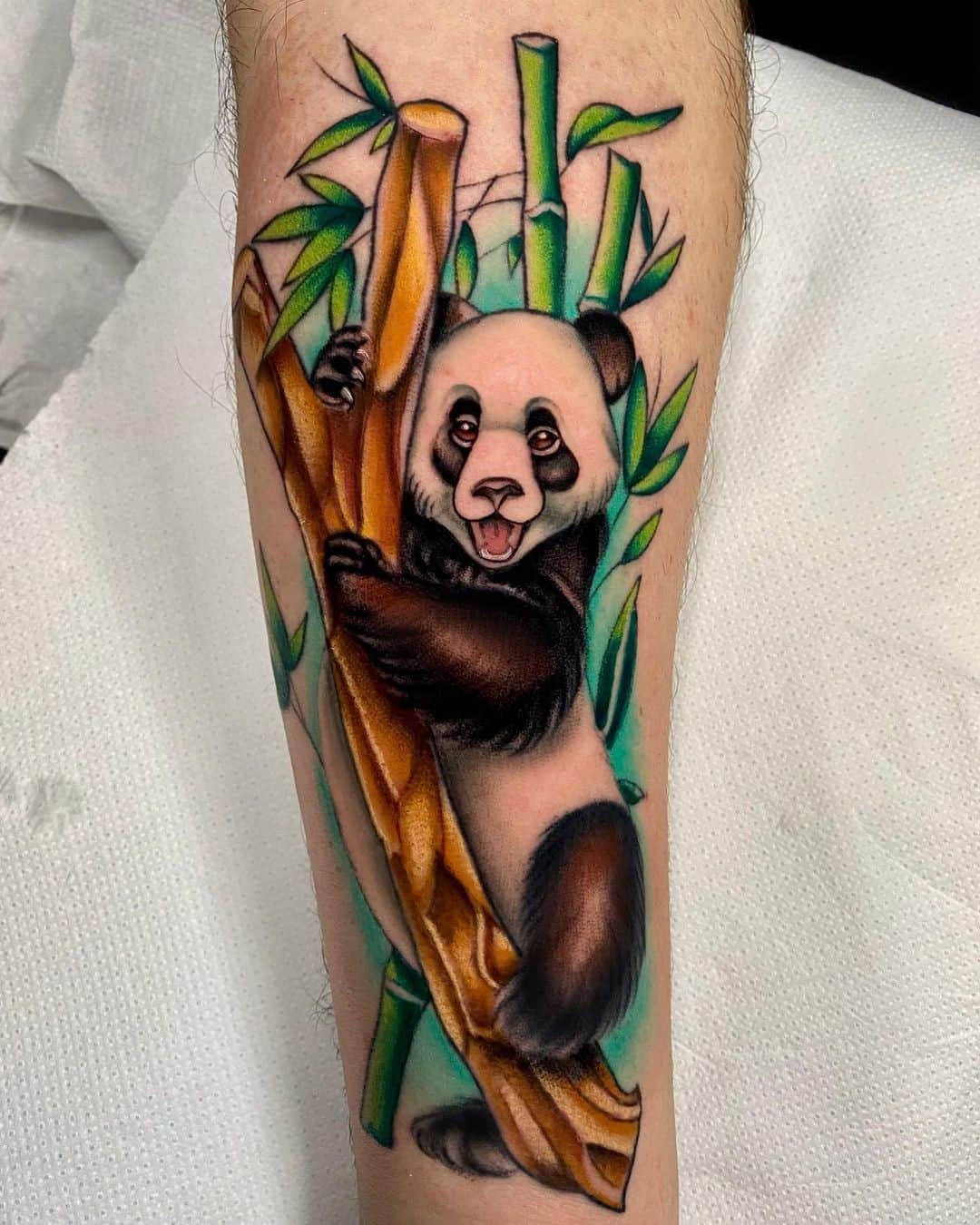 Colored panda tattoo on the forearm for men