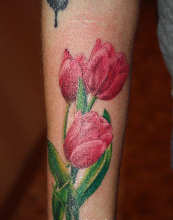 Color tattoo of a tulip on the forearm for men