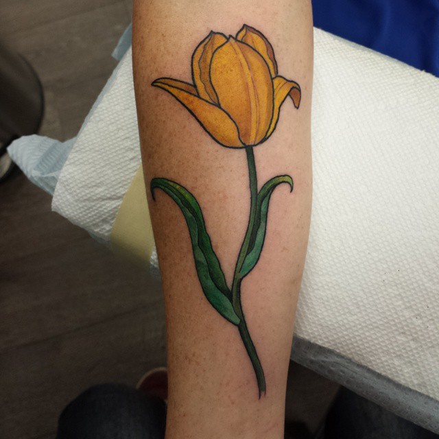 Color tattoo of a tulip on the forearm for men