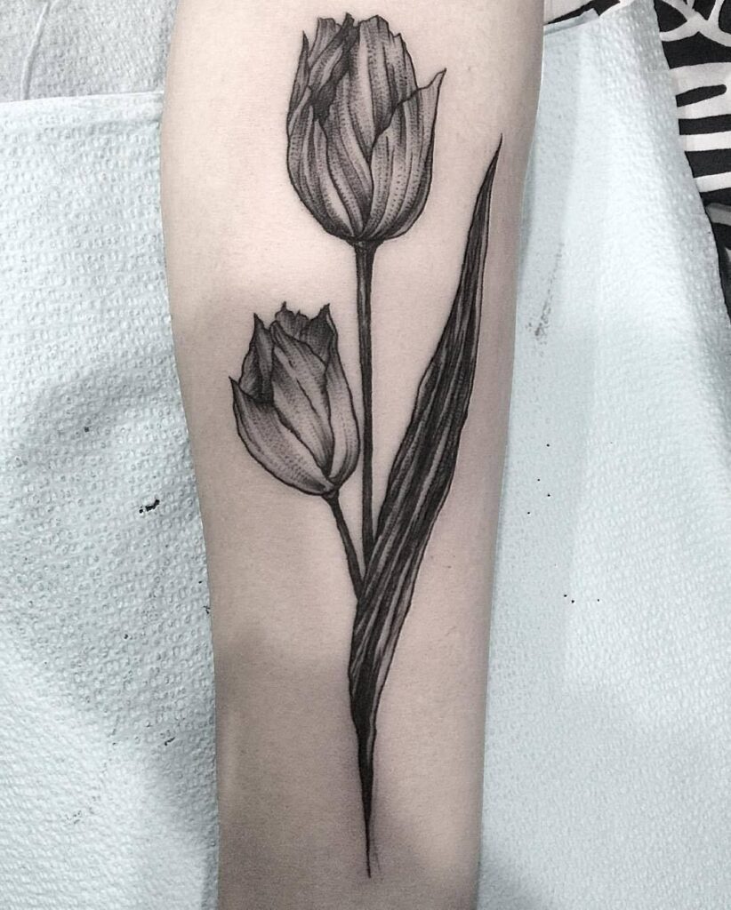 Large tulip tattoo on the forearm for women