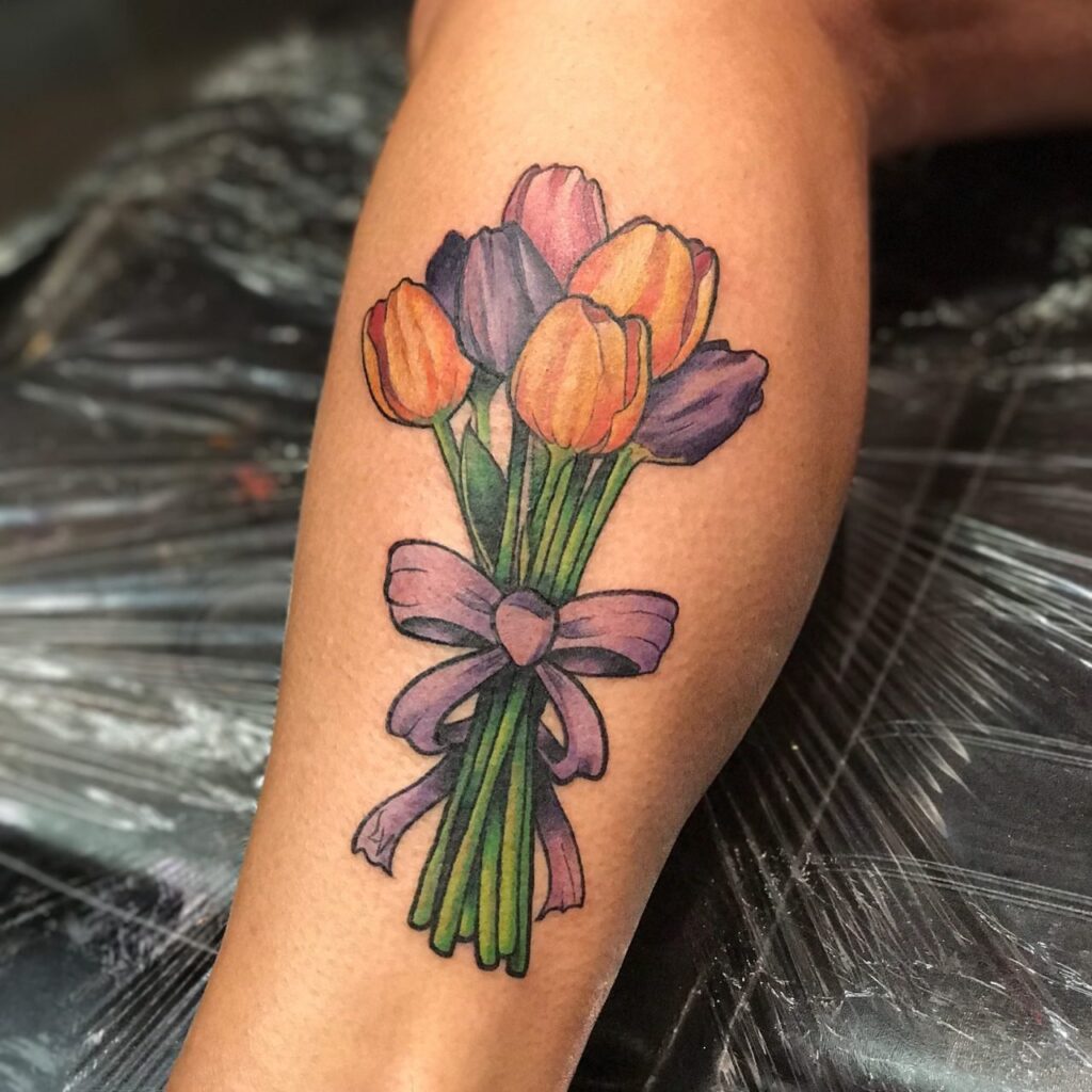 Colored tulip tattoo on the shin for women