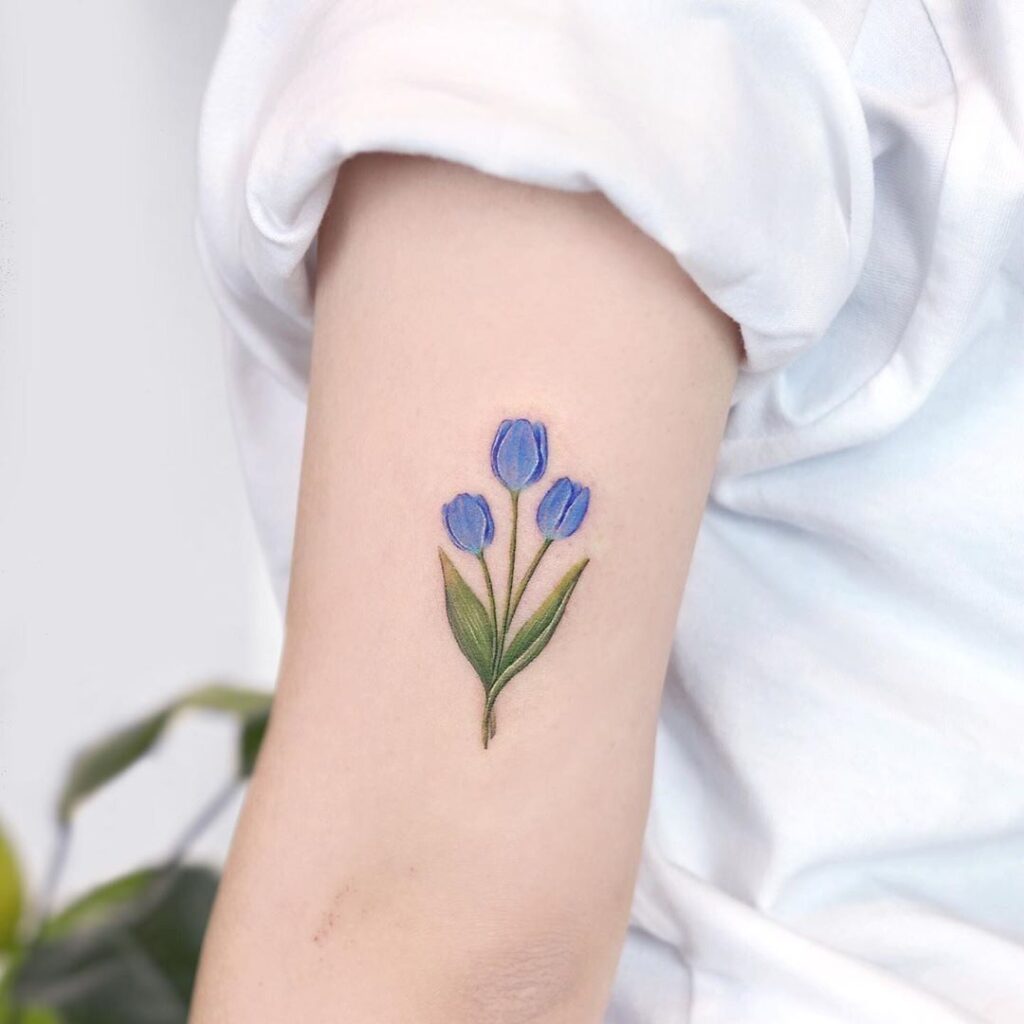 Color tattoo of a tulip on the shoulder for women