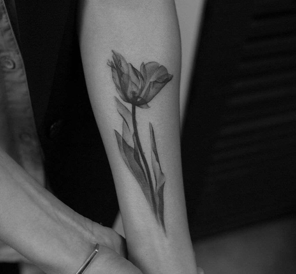 Large tulip tattoo on the forearm for women