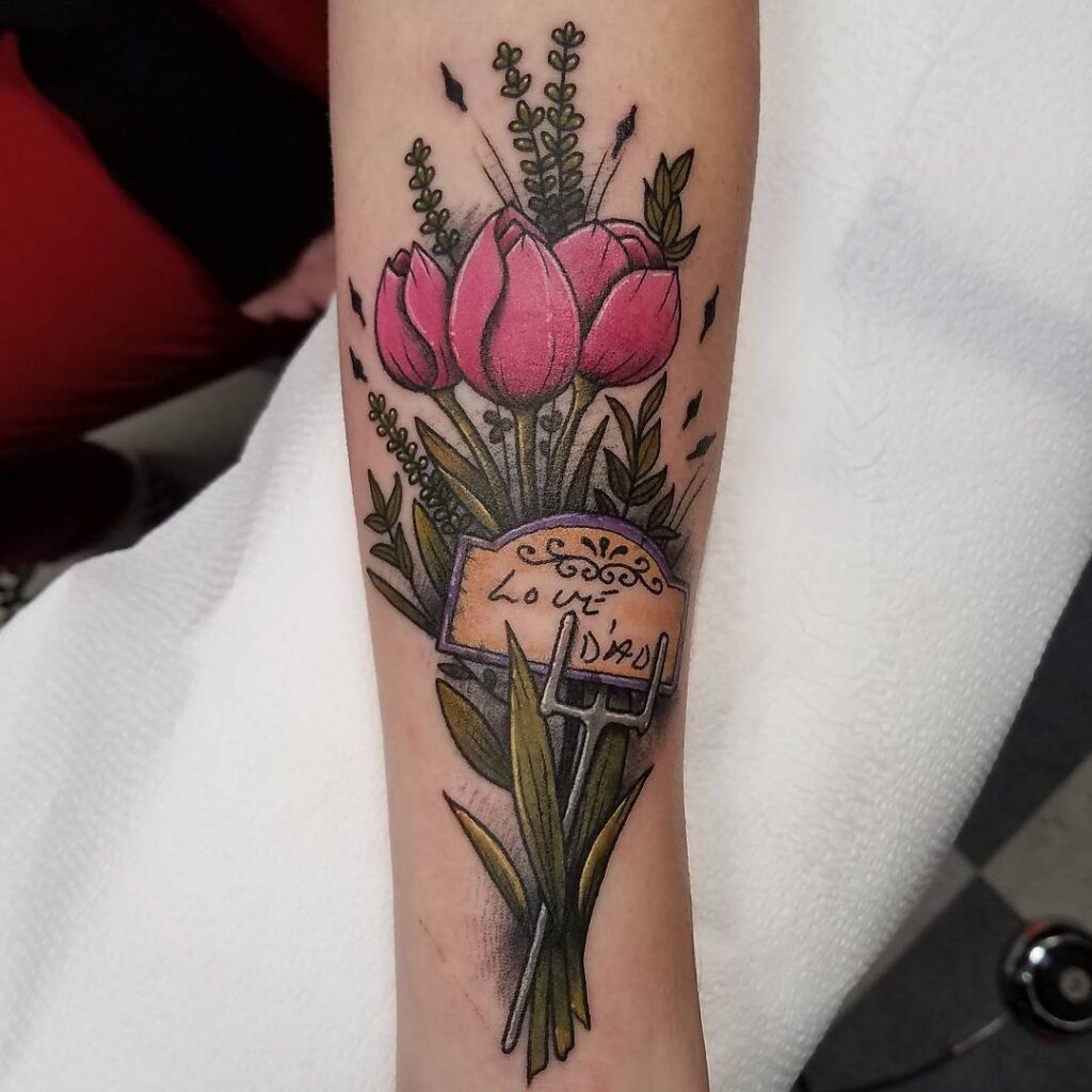 Colored tulip tattoo with an inscription on the forearm for women