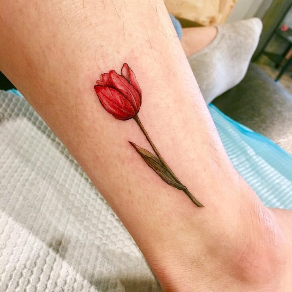 Colored tulip tattoo on the shin for men