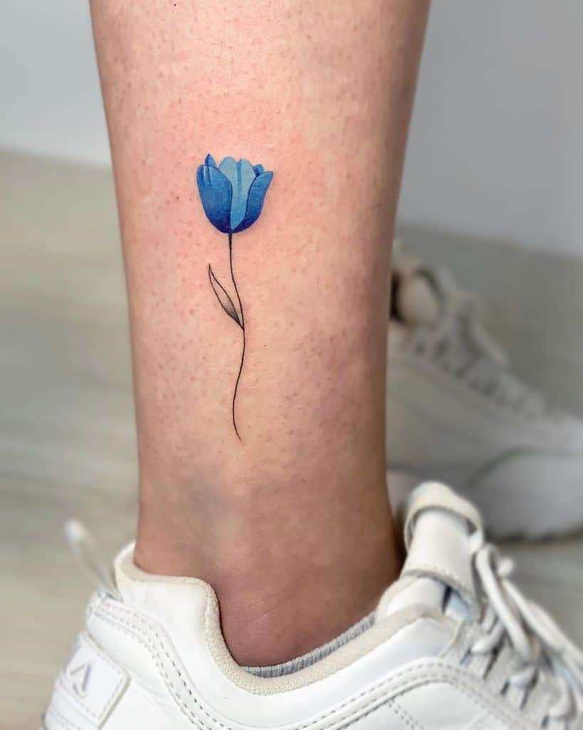 Colored tulip tattoo on the shin for men