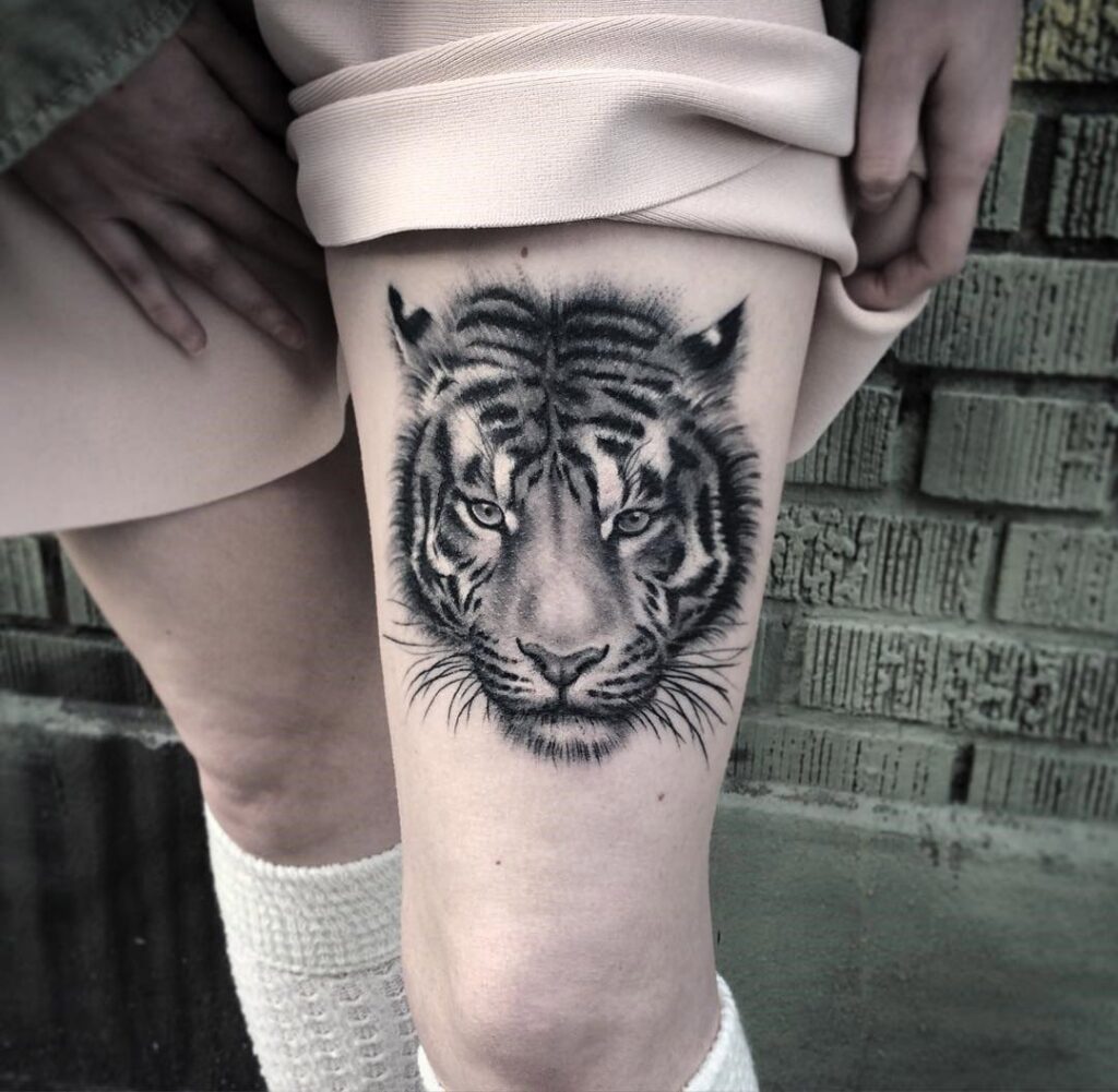 Tattoo of a tiger on the hip for women