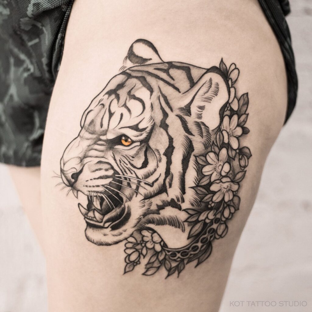 Tattoo of a tiger and flowers on the hip for women