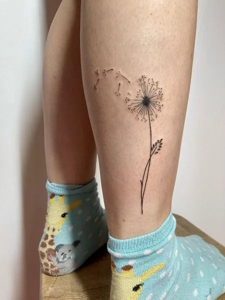 Dandelion tattoo on the shin for women