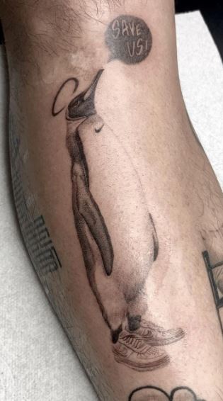 Tattoo of a penguin on the shin for men