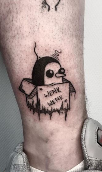 Tattoo of a penguin on the shin for men