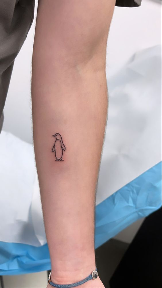 Penguin tattoo on the forearm for women