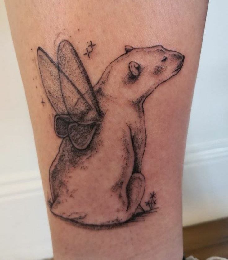 Tattoo of a bear with wings on the shin for women