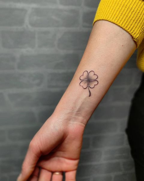 Tattoo of a clover on the forearm for women