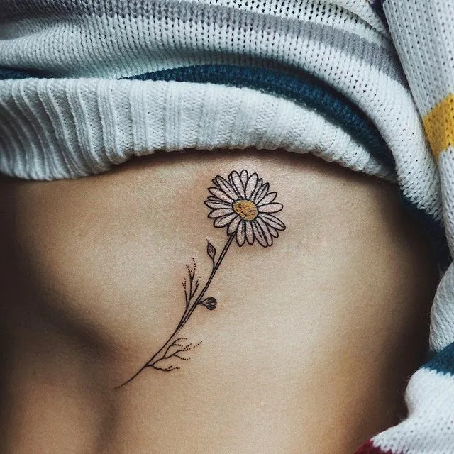 Colored daisy tattoo on the abdomen for women