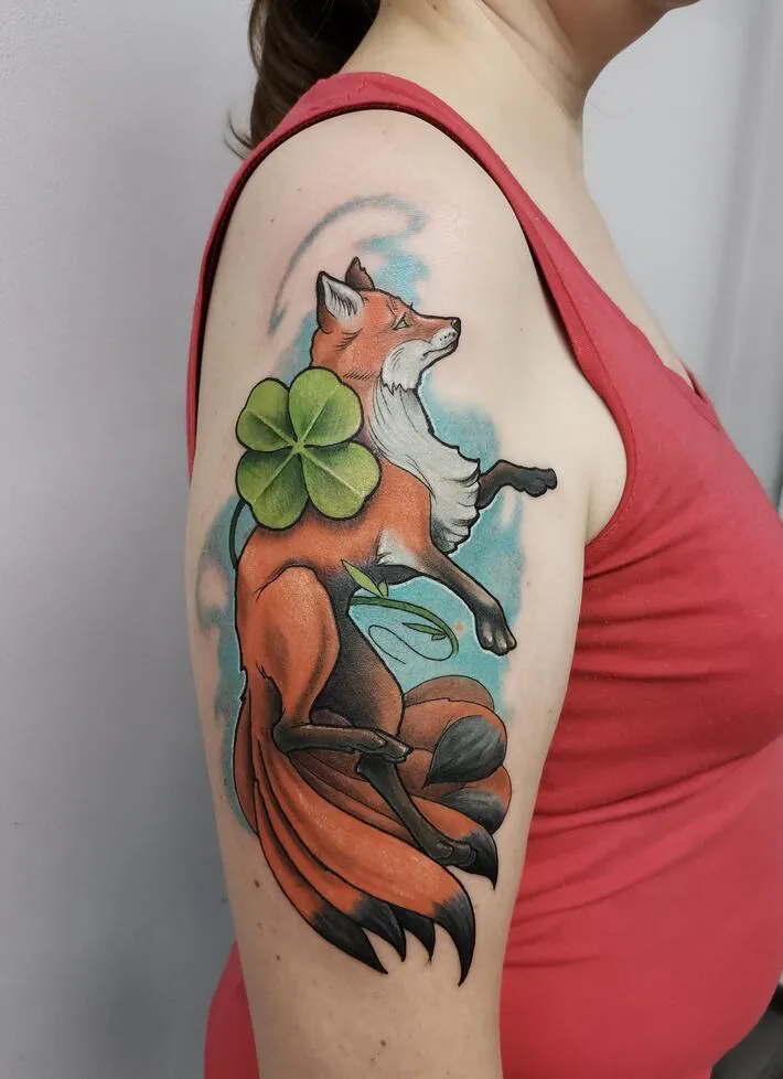 Tattoo of a colored fox on the shoulder for women