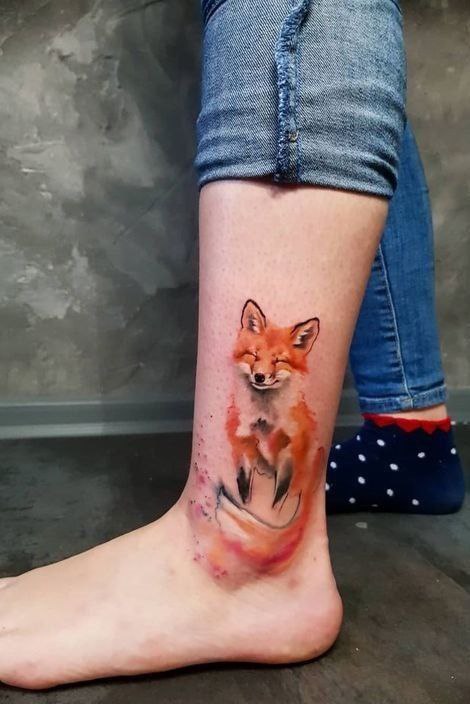 Tattoo of a colored fox on the shin for women