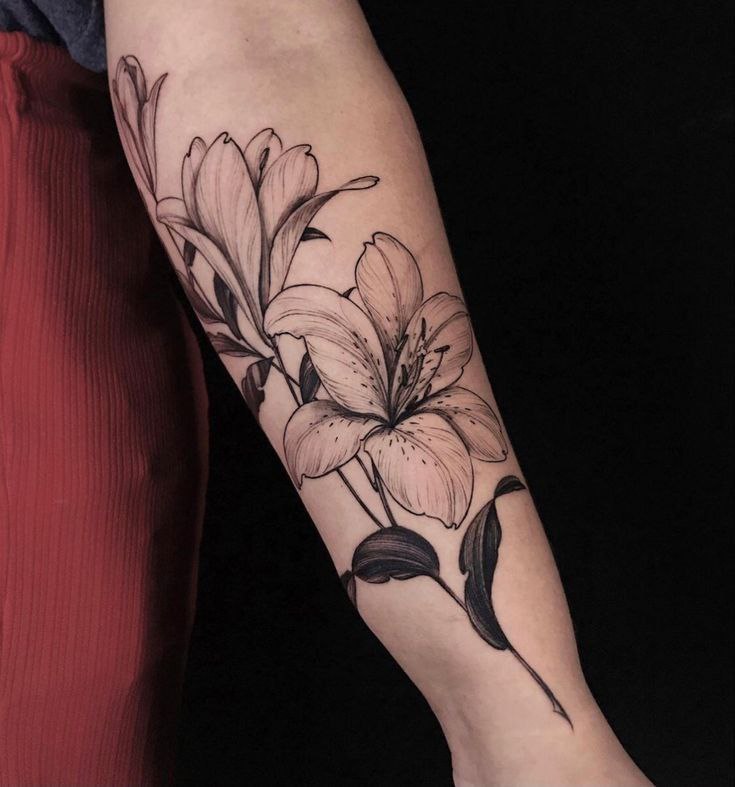 Large lily tattoo on forearm for women