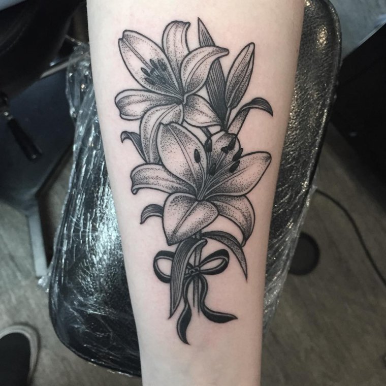 Large lily tattoo on the forearm for women