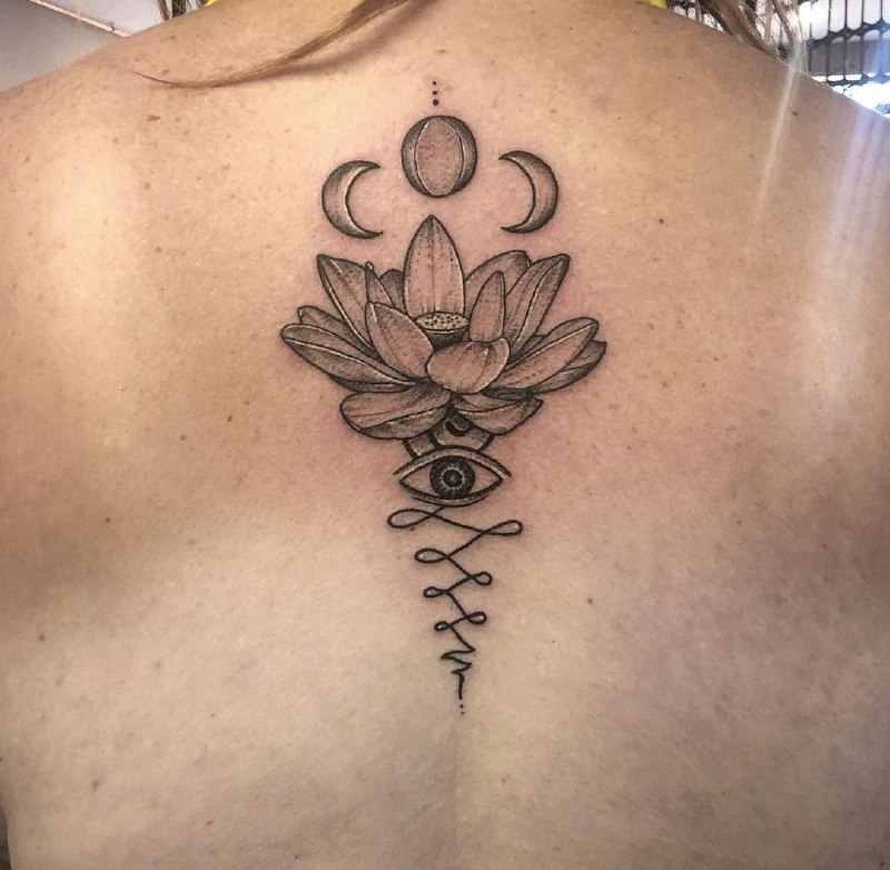 Lotus and month tattoo on the back for women