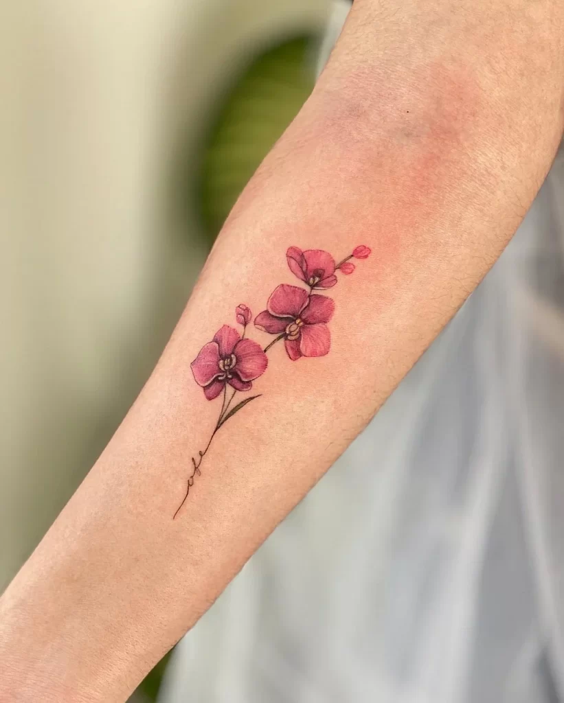 Color tattoo of orchid with inscription on forearm for women