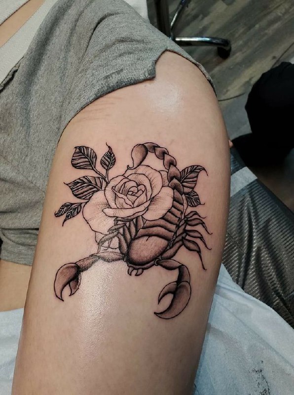 Scorpion tattoo with flowers on the thigh for women