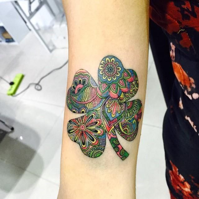 Colored clover tattoo on the forearm for women