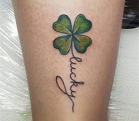 Colorful clover tattoo with inscription on the calf for women