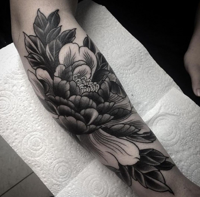 Large peony tattoo on the forearm for women