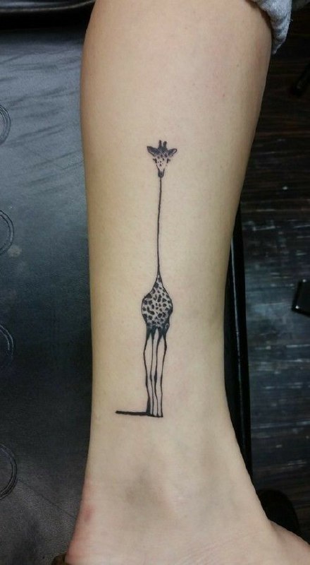 Giraffe tattoo on the shin for women