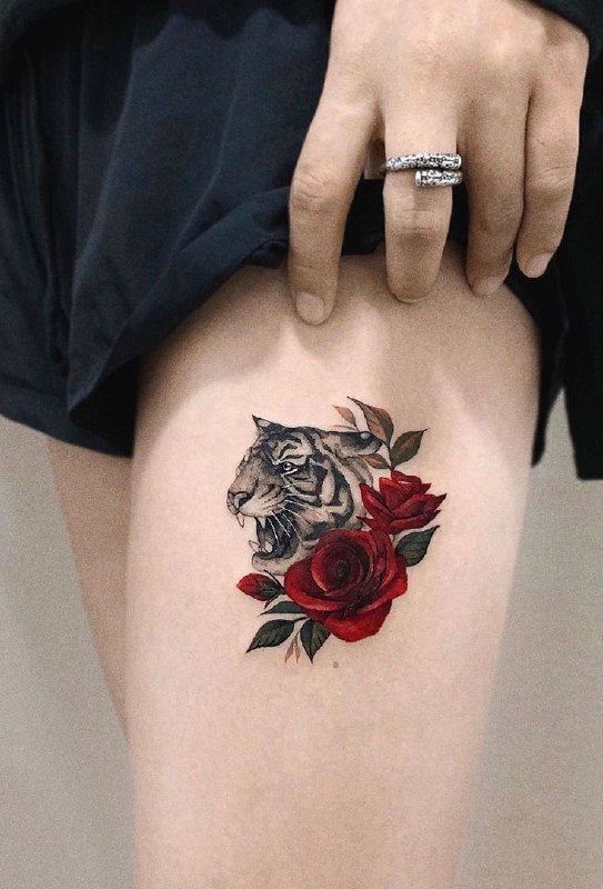 Tattoo of a tiger with roses on her thigh for women