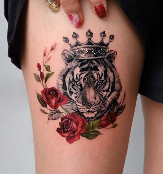 Tattoo of a tiger with roses on thigh for women