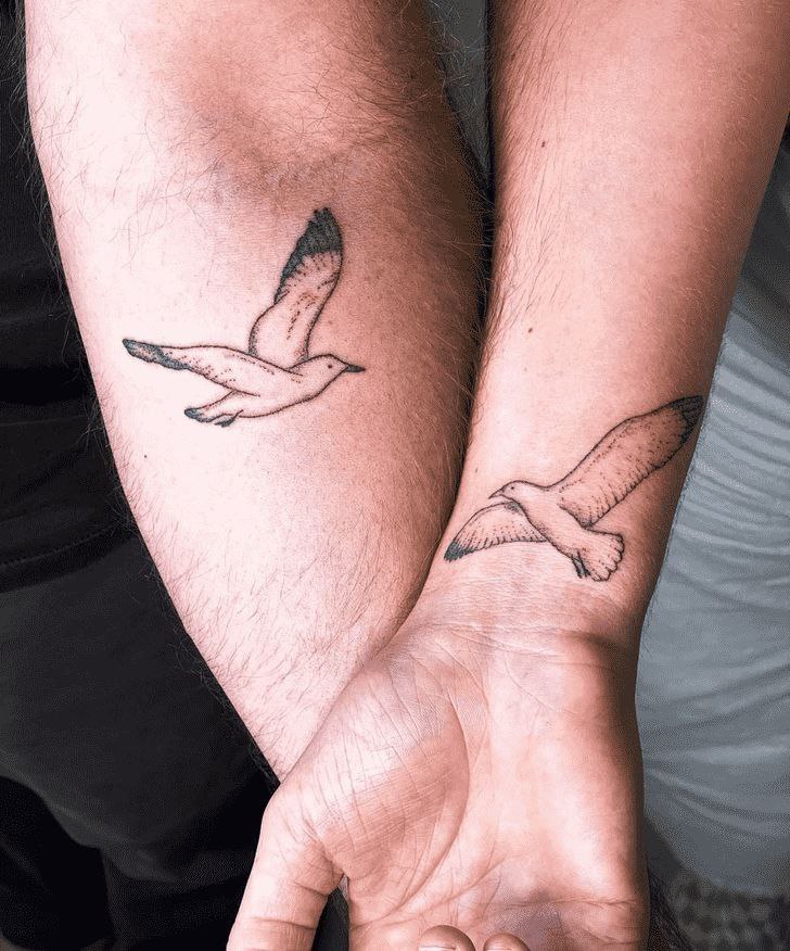 Tattoo of a seagull on the arms