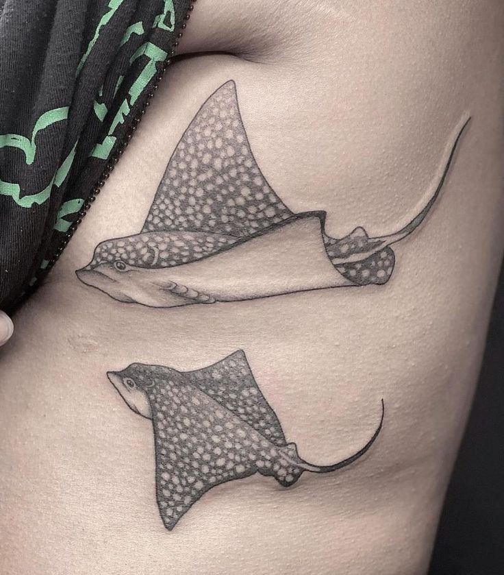 Tattoo of two stingrays on the side for women