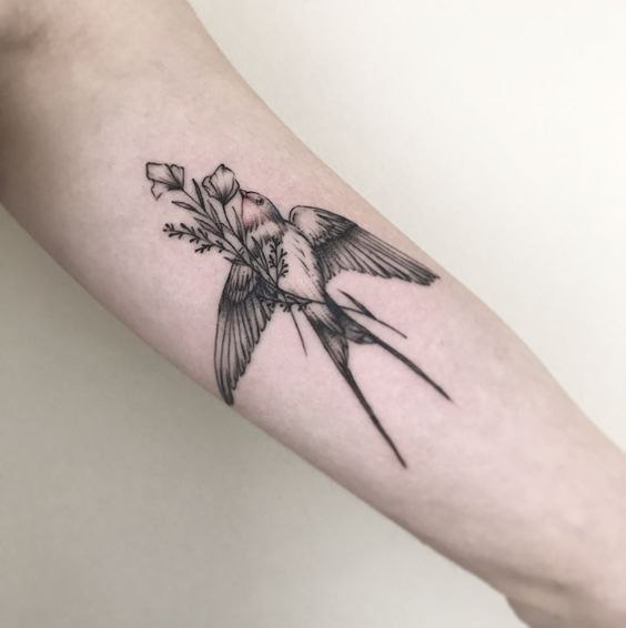 Swallow tattoo with flowers on forearm for women