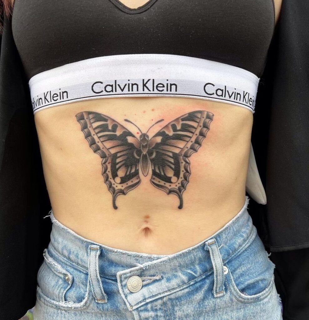 Large butterfly tattoo on the abdomen for women