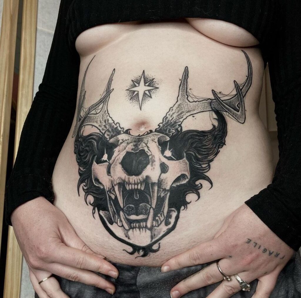 Large skull tattoo on the abdomen for women