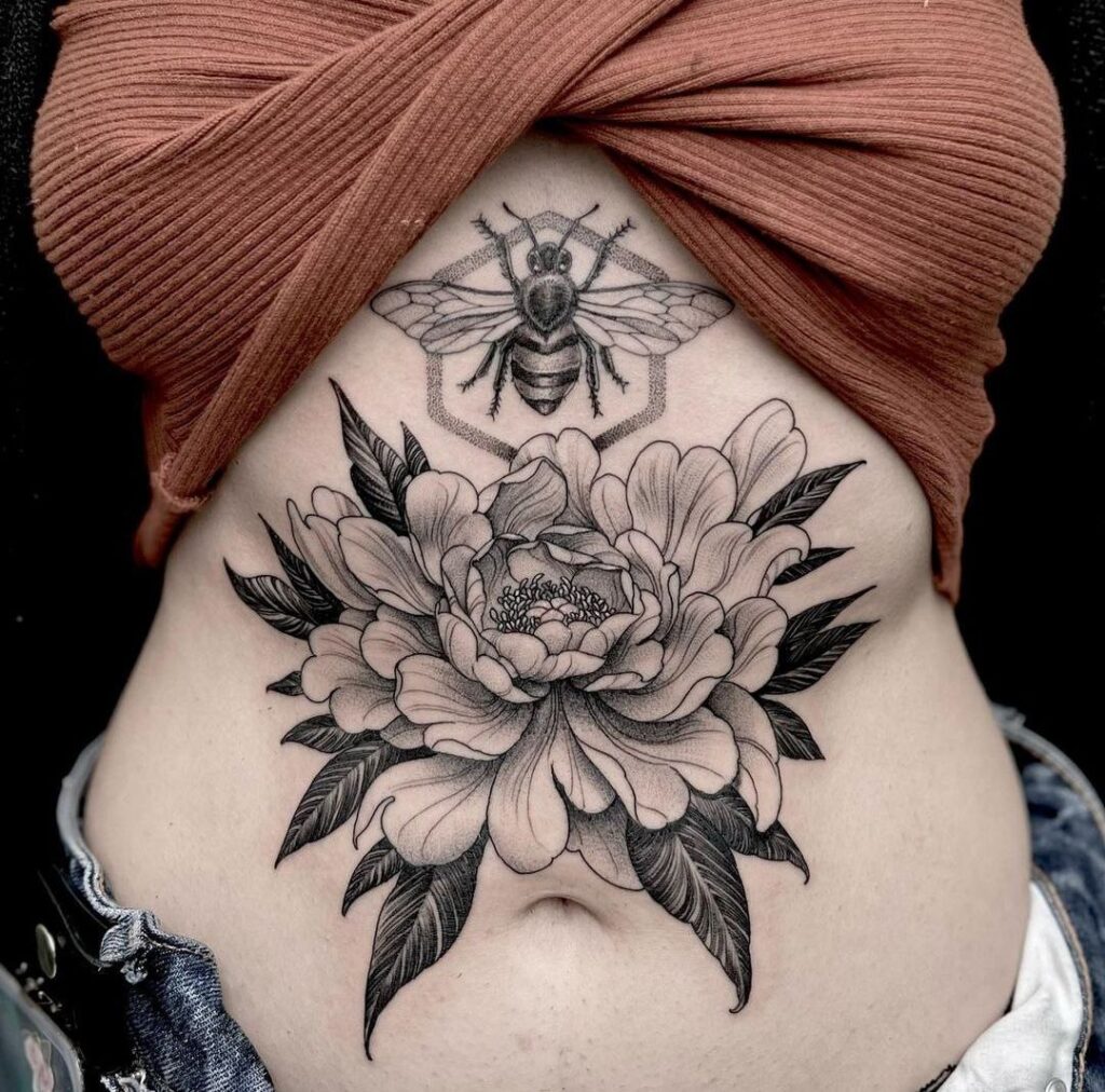 Large flower and wasp tattoo on the abdomen for women