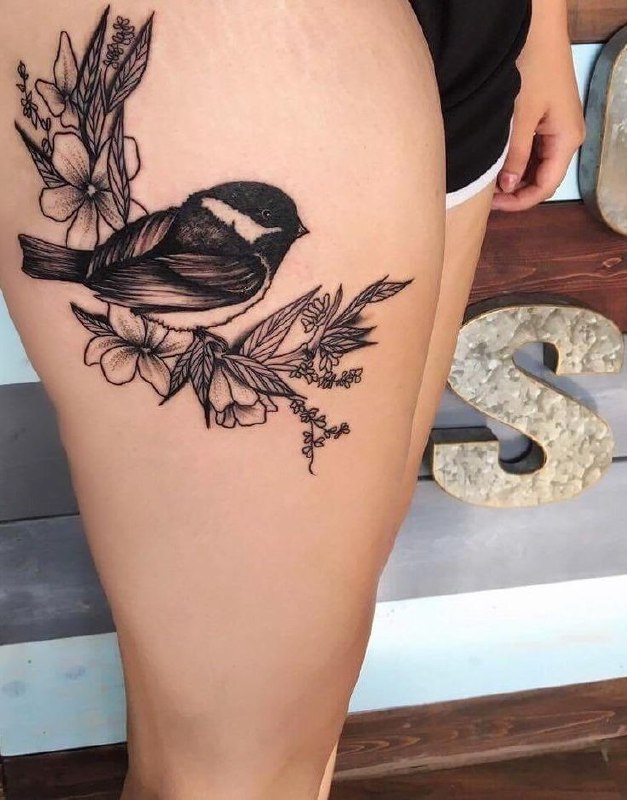 Large sparrow tattoo with flowers on the thigh for women