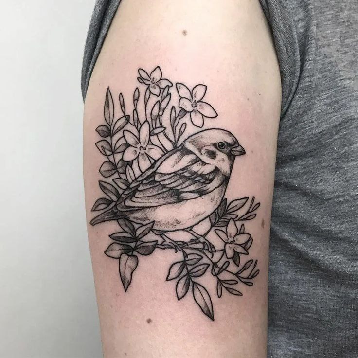 Tattoo of a sparrow with flowers on the shoulder for women