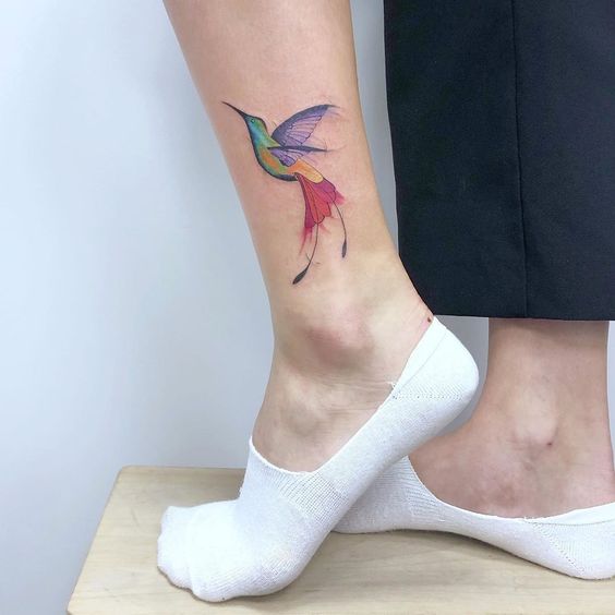 Colored hummingbird tattoo on the shin for women